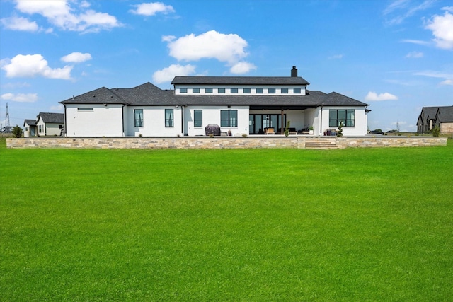 back of property with a lawn, a chimney, and a patio