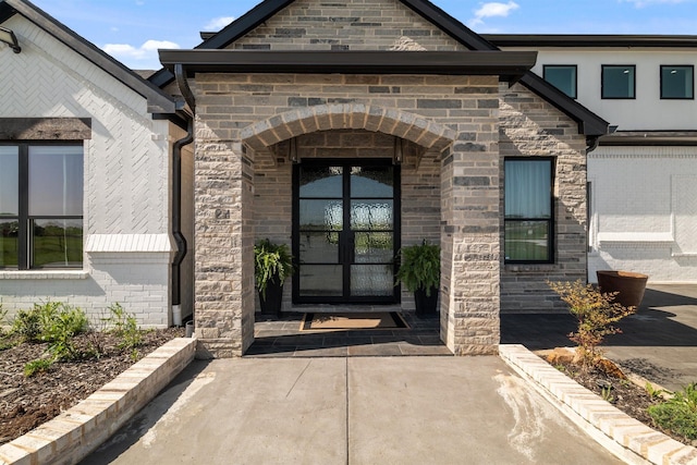 doorway to property featuring stone siding and french doors