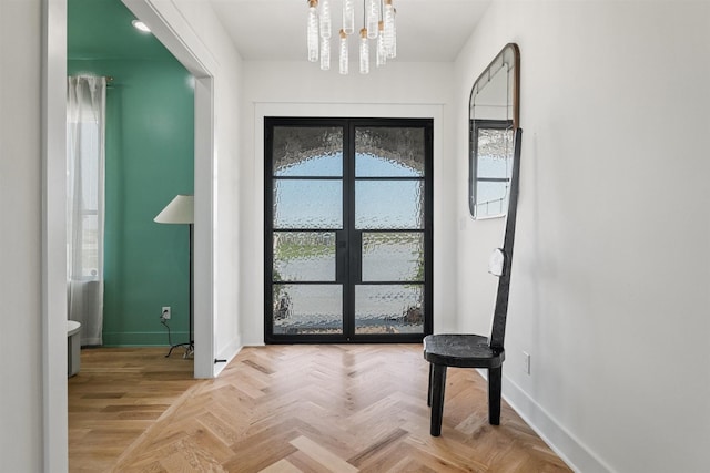 entryway with baseboards and an inviting chandelier