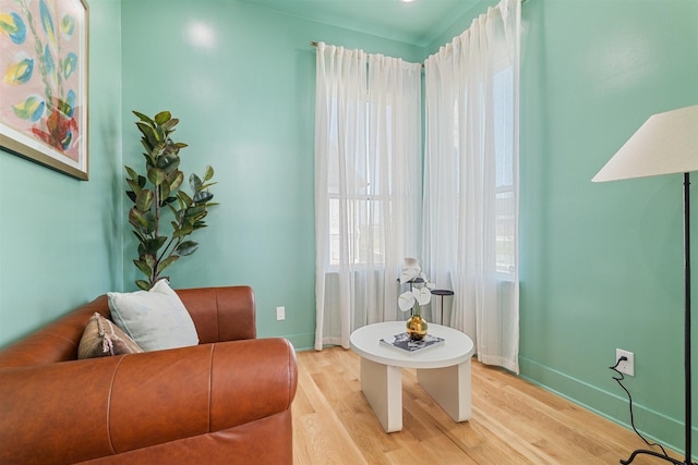 living area with light wood-style flooring and baseboards