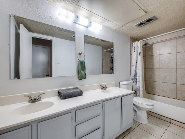 full bath featuring double vanity, a textured ceiling, a sink, and toilet