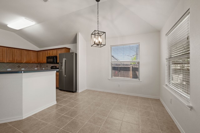 kitchen featuring stainless steel fridge with ice dispenser, an inviting chandelier, dark countertops, black microwave, and vaulted ceiling