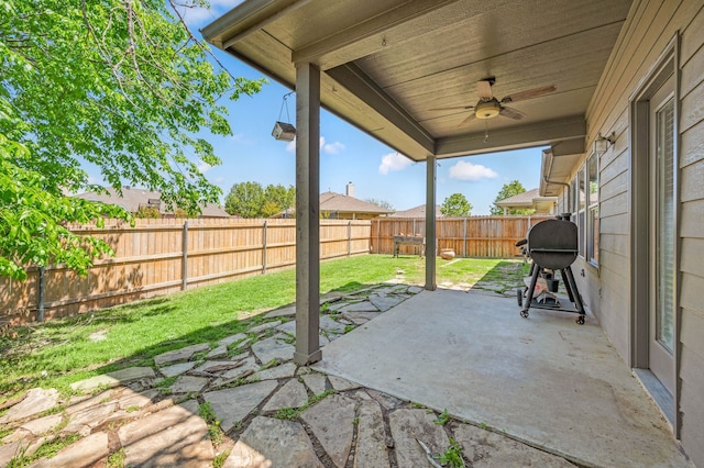 view of patio / terrace with grilling area, a fenced backyard, and ceiling fan