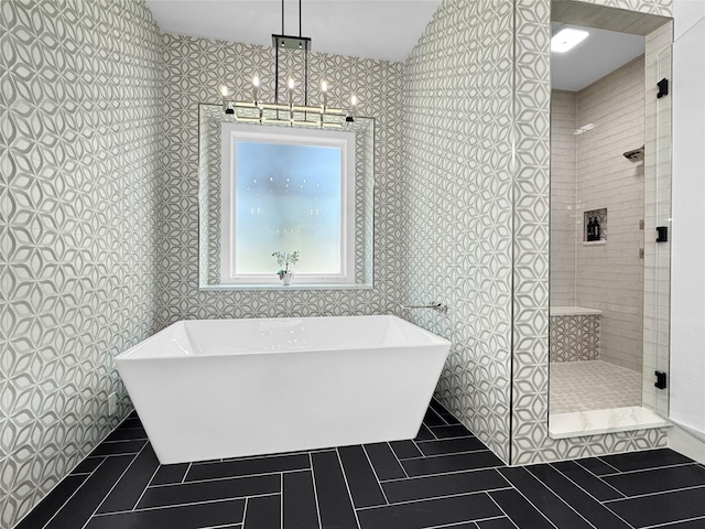 bathroom featuring a freestanding bath, a shower stall, and tile patterned flooring