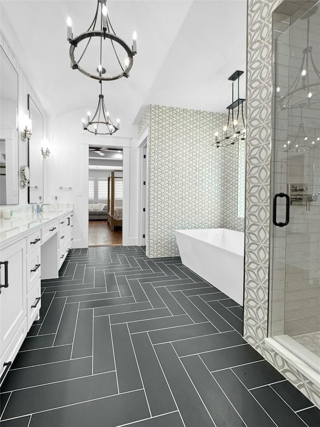 bathroom featuring a freestanding tub, a shower stall, vanity, tile patterned floors, and an inviting chandelier