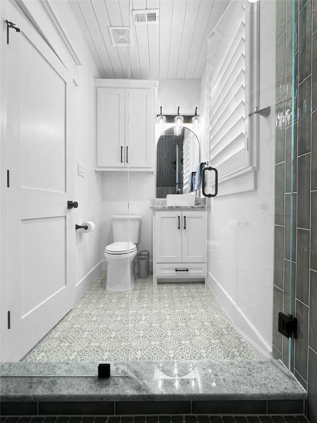 bathroom with baseboards, vanity, toilet, and visible vents