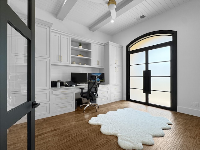 office with visible vents, built in desk, wooden ceiling, beamed ceiling, and light wood-style flooring