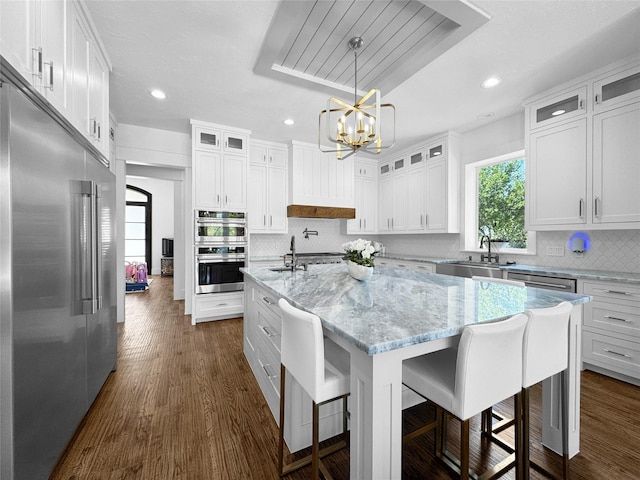 kitchen with stainless steel appliances, recessed lighting, a sink, and an inviting chandelier