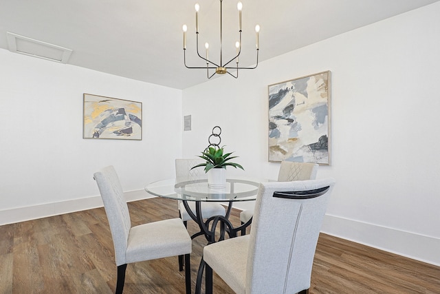dining room featuring baseboards, a chandelier, and wood finished floors