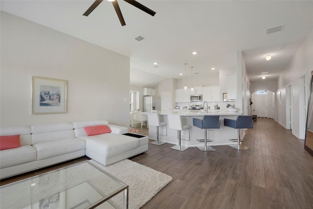living area with dark wood-style floors, a ceiling fan, and visible vents