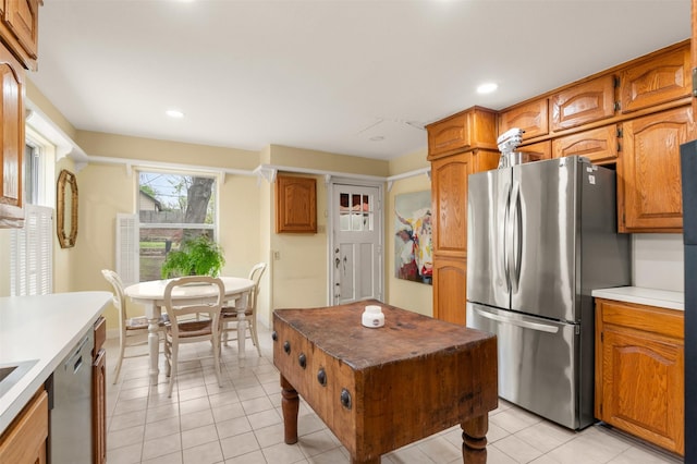 kitchen with light tile patterned floors, brown cabinetry, appliances with stainless steel finishes, and recessed lighting