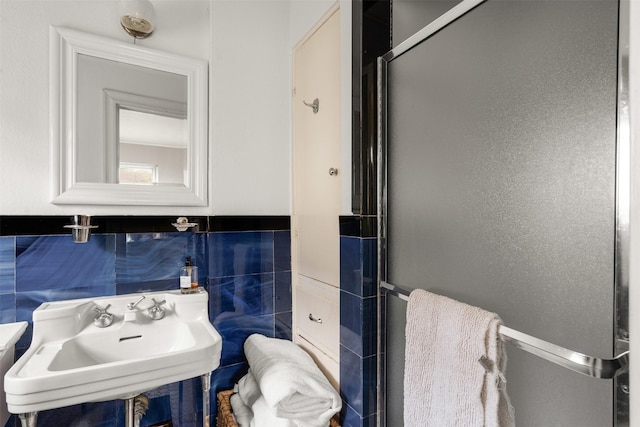 bathroom featuring a sink, tile walls, and wainscoting