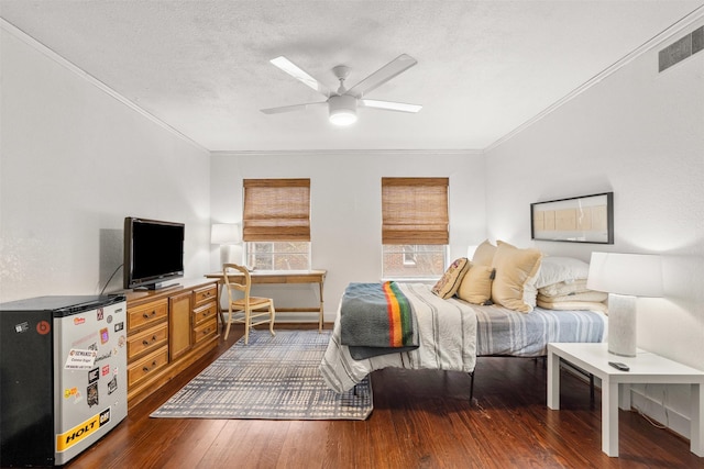 bedroom featuring visible vents, freestanding refrigerator, a textured ceiling, crown molding, and hardwood / wood-style floors