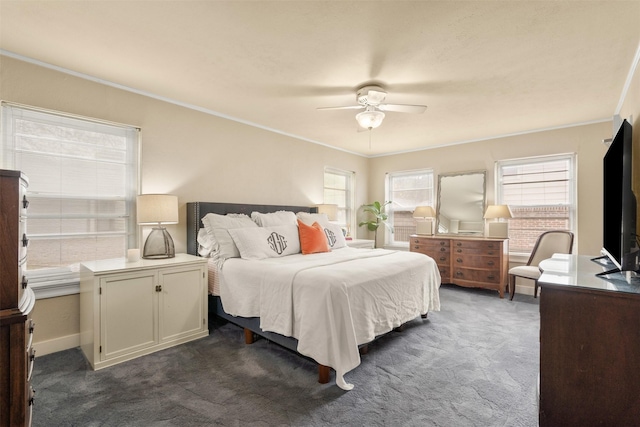bedroom featuring dark colored carpet, crown molding, and ceiling fan