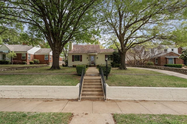 view of front facade with a front lawn, stucco siding, and a chimney