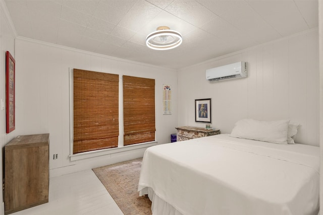 bedroom with a wall unit AC, ornamental molding, and wood finished floors