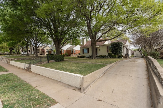 view of front of house with a residential view, a chimney, fence, and a front lawn
