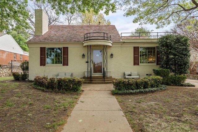view of front of home featuring a chimney, fence, and brick siding