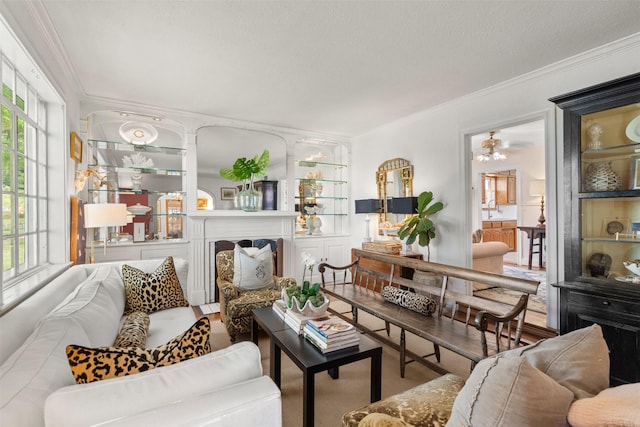 living area featuring a textured ceiling, ceiling fan, and ornamental molding