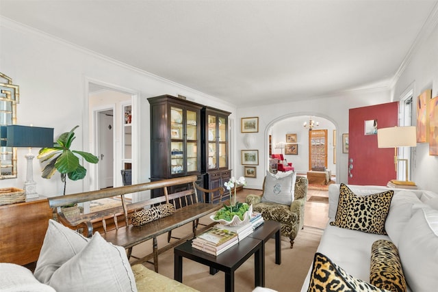 living area featuring ornamental molding, arched walkways, and a notable chandelier