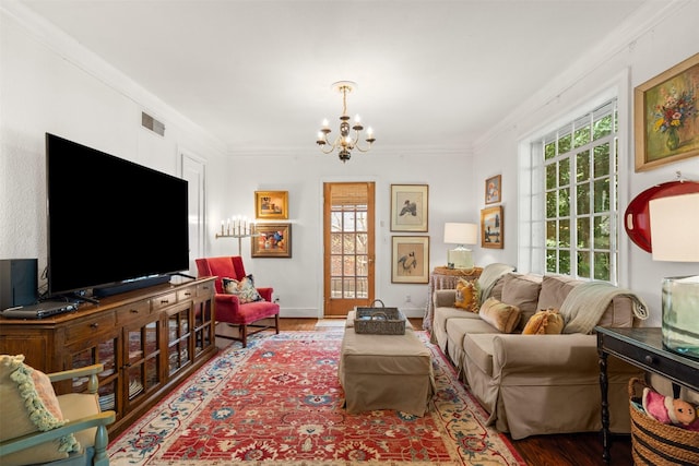 living room featuring plenty of natural light, a notable chandelier, ornamental molding, and wood finished floors