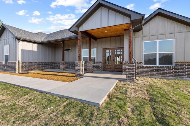 1510 S Shore Dr, Bonham, TX 75418 - entrance to property featuring french doors, brick siding, covered porch, and roof with shingles