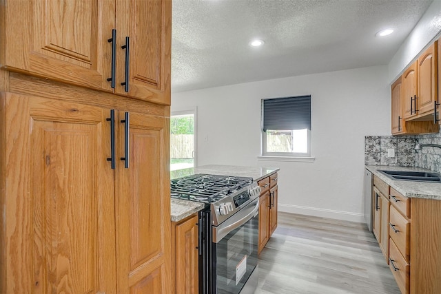 436 Nathan St, Burleson, TX 76028 - kitchen featuring appliances with stainless steel finishes, a sink, a textured ceiling, baseboards, and tasteful backsplash