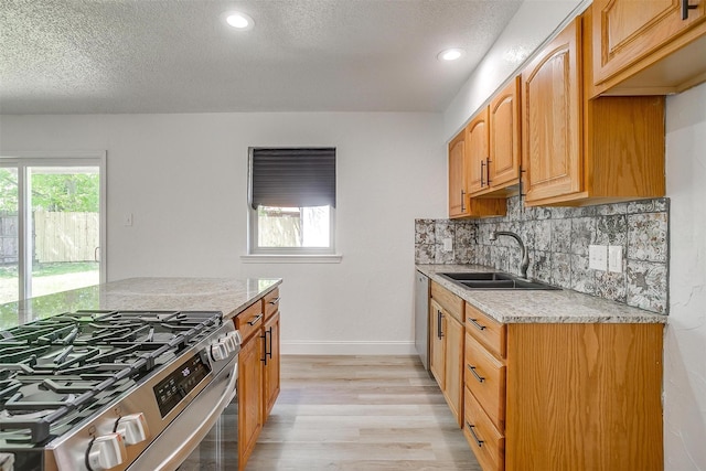 436 Nathan St, Burleson, TX 76028 - kitchen featuring stainless steel appliances, a sink, a textured ceiling, light wood-style flooring, and tasteful backsplash