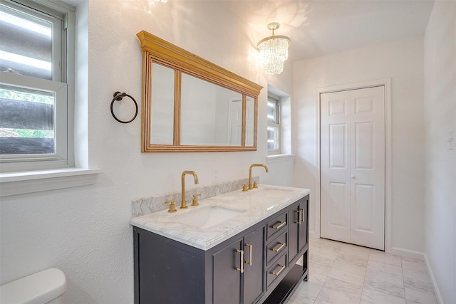 436 Nathan St, Burleson, TX 76028 - bathroom with marble look tile flooring, double vanity, toilet, baseboards, and a chandelier