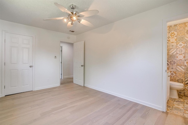 436 Nathan St, Burleson, TX 76028 - unfurnished bedroom featuring light wood-style flooring, baseboards, connected bathroom, a ceiling fan, and a textured ceiling