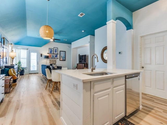 kitchen with stainless steel dishwasher, visible vents, a sink, open floor plan, and light wood finished floors