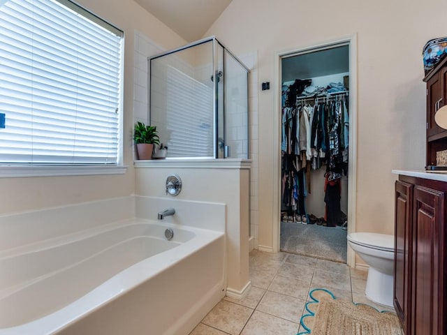 bathroom with a bath, toilet, a shower stall, vanity, and tile patterned floors