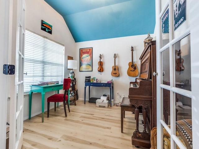 interior space with french doors, wood finished floors, baseboards, and lofted ceiling