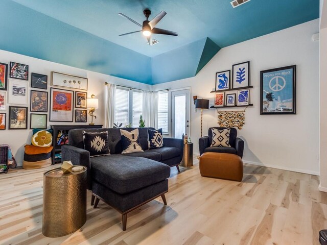 living room featuring wood finished floors, baseboards, a ceiling fan, and vaulted ceiling
