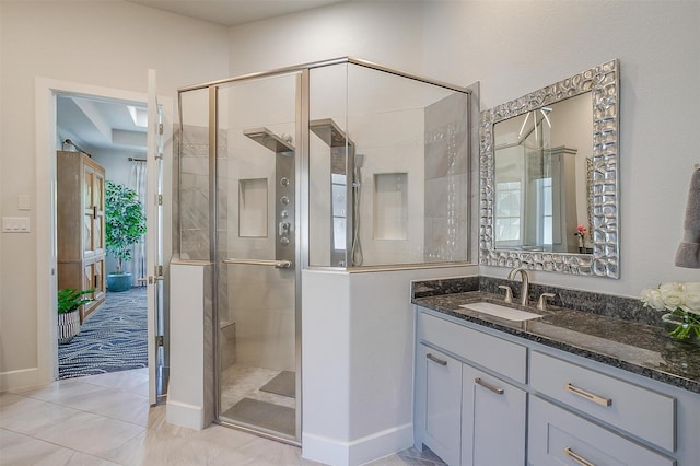 full bath featuring vanity, baseboards, and a stall shower