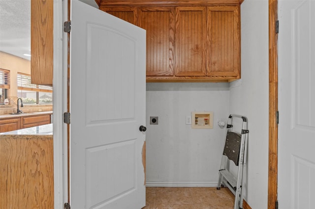 washroom with a sink, hookup for an electric dryer, cabinet space, baseboards, and washer hookup