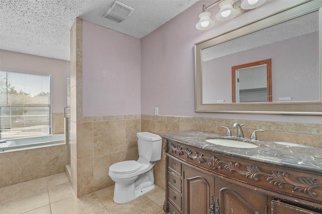 full bath featuring a textured ceiling, vanity, toilet, tile patterned flooring, and visible vents