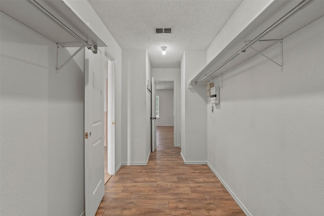 walk in closet featuring wood finished floors and visible vents