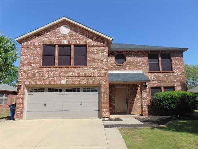 traditional-style house featuring roof with shingles, concrete driveway, a garage, and brick siding
