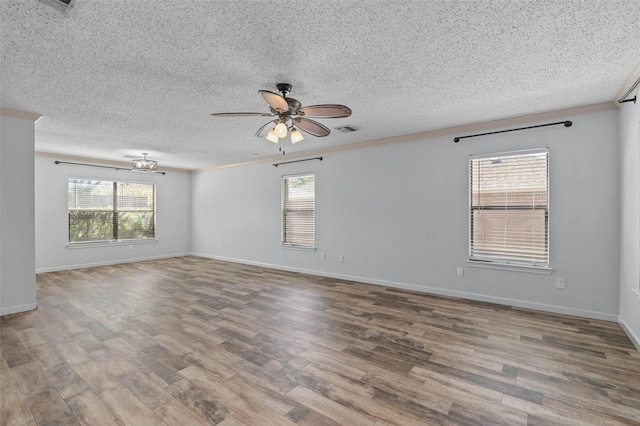 unfurnished room with a textured ceiling, plenty of natural light, visible vents, and ceiling fan