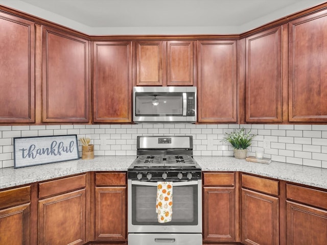 kitchen with dark brown cabinets, backsplash, light stone countertops, and stainless steel appliances