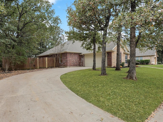 ranch-style home with driveway, an attached garage, a front lawn, brick siding, and fence