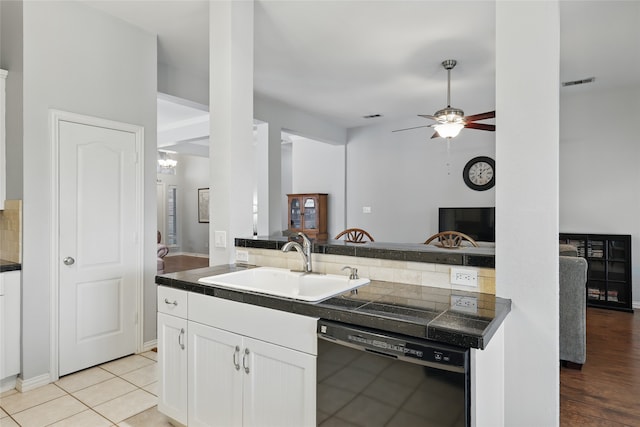 kitchen featuring open floor plan, white cabinetry, visible vents, dishwasher, and a sink