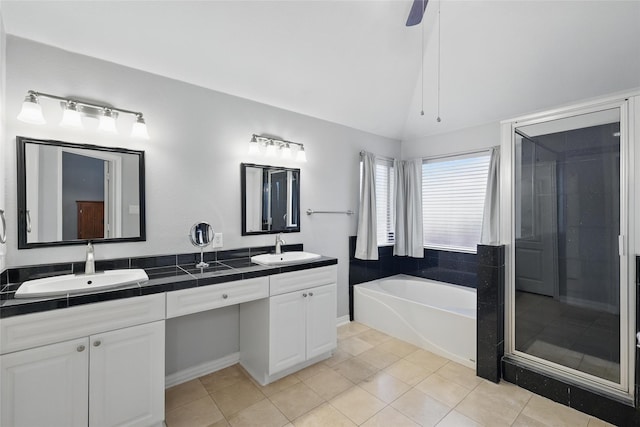 full bath with a shower stall, double vanity, a garden tub, and a sink