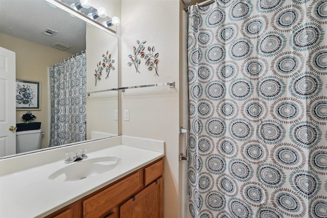 bathroom with visible vents, toilet, a shower with shower curtain, and vanity