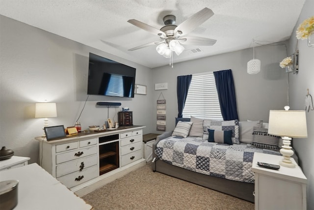 bedroom with carpet flooring, visible vents, a textured ceiling, and ceiling fan
