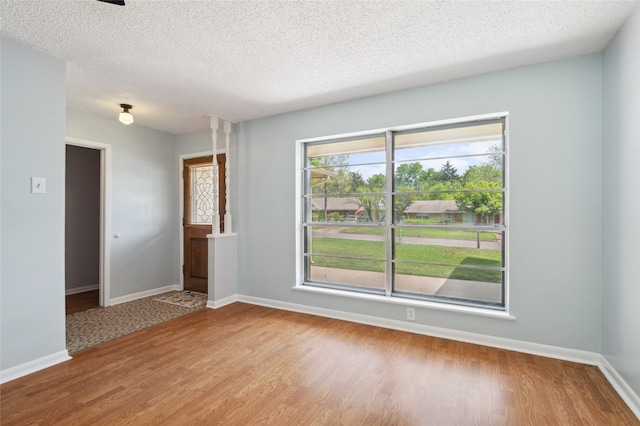 1120 S Valentine Dr, Sherman, TX 75090 - spare room featuring wood finished floors, baseboards, and a textured ceiling