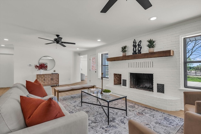 living room with recessed lighting, a fireplace, a ceiling fan, and wood finished floors