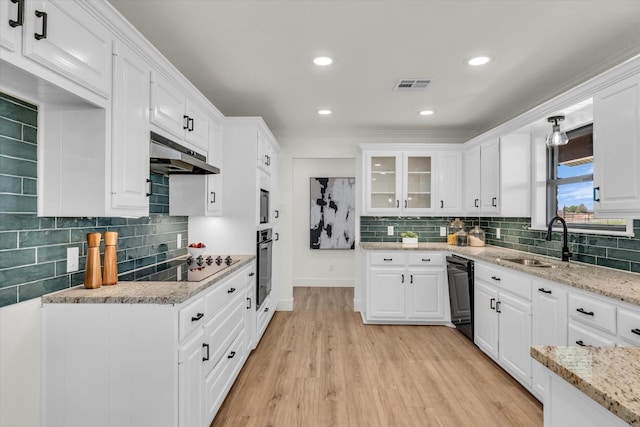 kitchen featuring under cabinet range hood, visible vents, white cabinetry, and black appliances