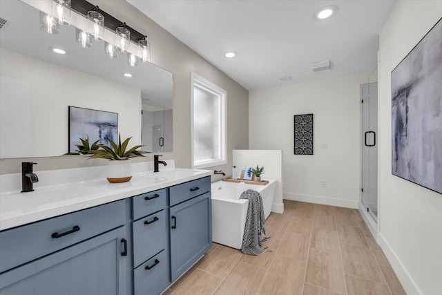 bathroom with a sink, a shower stall, a freestanding bath, and double vanity